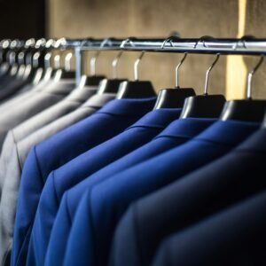 Close-up of neatly arranged suits in a wardrobe, showcasing fashion and organization.